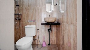 Une salle de bain avec des toilettes, un lavabo et une douche.