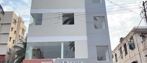 A multi-story building with a Riva Inn sign, featuring a modern design with large windows and a flat roof.