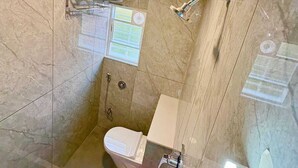 A small, modern bathroom with a shower, toilet, and a glass-enclosed bathtub. - HOTEL RIVA INN (Miraj)