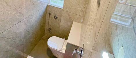 Un baño pequeño y moderno con ducha, inodoro y bañera con mampara de vidrio.