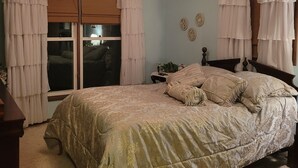 A bedroom with a bed, a ceiling fan, and a window with curtains. - Peaceful riverfront home, 3 bedroom,  sleeps 6, in Elkhart. (Elkhart)