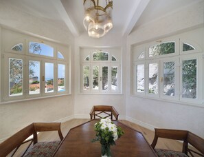 A dining room with a wooden table and chairs, large arched windows, and a chandelier. - Villa Admiral Fantastic 5-bedroom villa with AC in Dubrovnik (Dubrovnik)