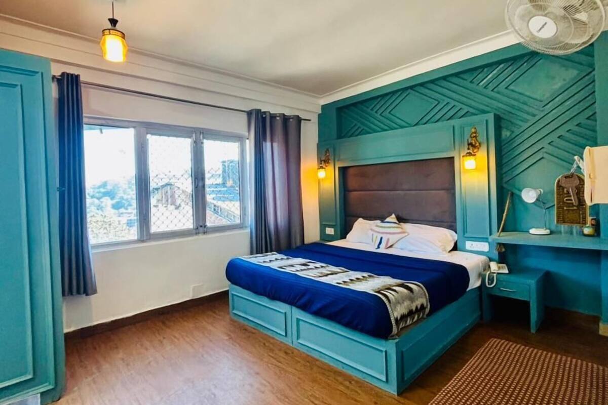 A bedroom with a bed, bedside table, and a window.