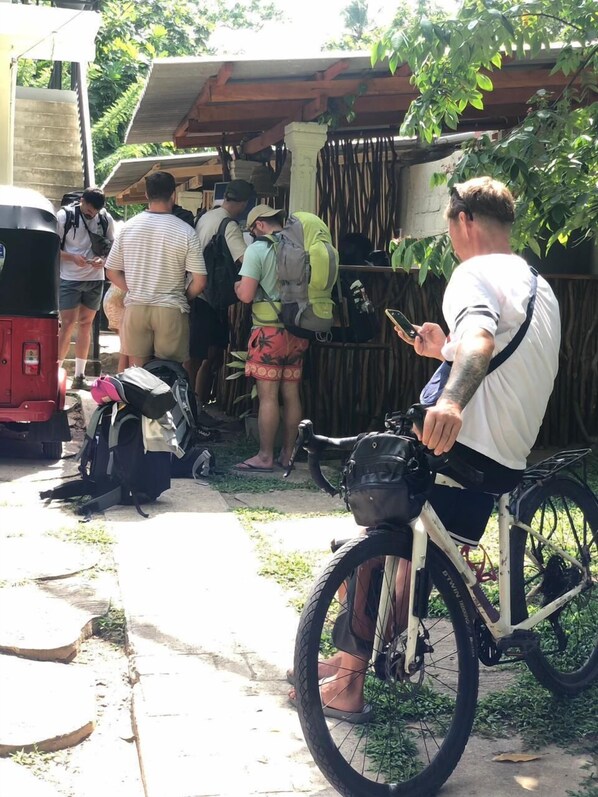 A group of people gathered around a vehicle, possibly a van, with a bicycle parked nearby. - Wake N Flow, Ahangama (Ahangama)