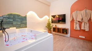 Un baño moderno con bañera, cartel de Netflix y perchero de pared.