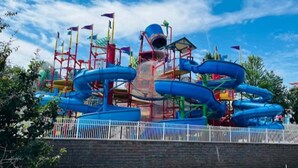 Een waterpark met glijbanen en een centraal gebouw.