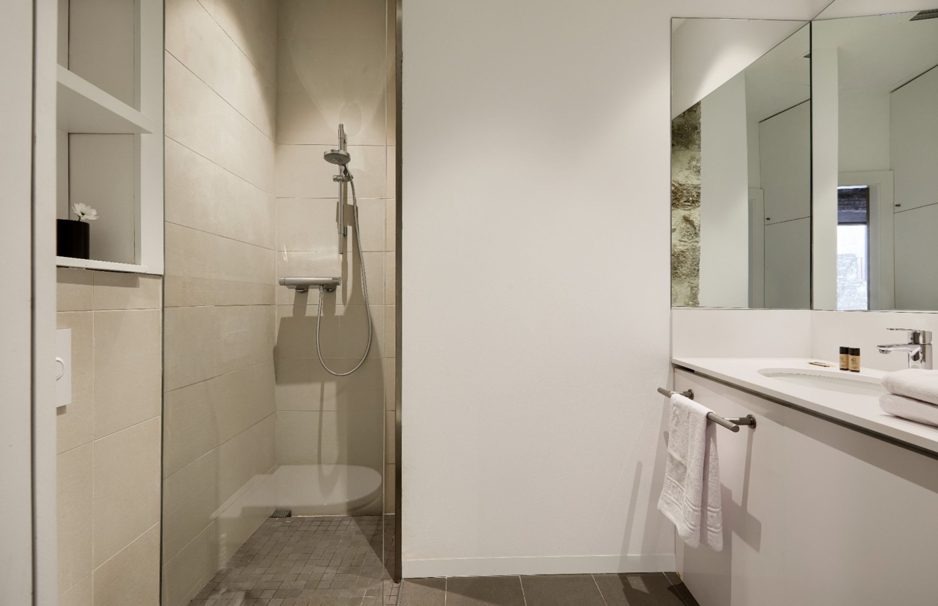 A modern bathroom with a shower, toilet, and sink.