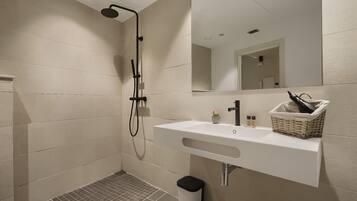 Une salle de bain moderne avec une douche, un lavabo et un miroir.