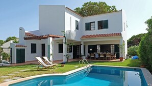 A two-story white house with a swimming pool, outdoor seating, and a garden. - VV Beautiful Villa w/pool | A/C | VILAMOURA! (Quarteira)