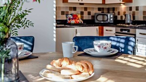 Une table à manger avec des croissants, une tasse à motifs floraux et une tasse blanche.