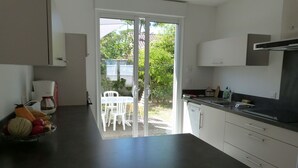 Een moderne keuken met een schuifdeur naar een buitenruimte.