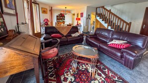 A living room with a brown leather sofa, a wooden coffee table, and a patterned rug. - Duplex with Terrace and Private Beach Access, Garage Included (Évian-les-Bains)