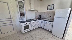 A kitchen with a gas stove, oven, sink, and a Liebherr refrigerator. - House near beach and downtown La Faute-sur-Mer (La Faute-sur-Mer)