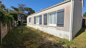 A single-story building with a flat roof, a small front porch, and a window with shutters. - House near beach and downtown La Faute-sur-Mer (La Faute-sur-Mer)