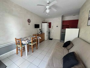 A compact living space with a dining area, kitchenette, and a sofa. - Cozy city-center apartment, 400m from beaches, parking included (La Tranche-sur-Mer)