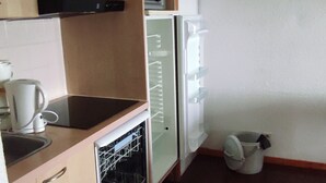 Eine kompakte Küche mit Geschirrspüler, Mikrowelle und Spüle.