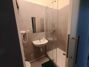 Basic-lejlighed | Badeværelse | Bruser, gratis toiletartikler, hårtørrer, håndklæder