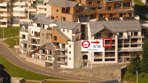 Un ensemble d’immeubles modernes formant un complexe résidentiel, avec de nombreux balcons et une route au premier plan.