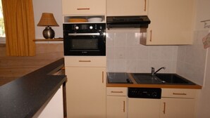 A compact kitchen with a stove, oven, dishwasher, and a sink. - Gourette: Duplex Studio 7 pers, Pool & WIFI (Gourette)