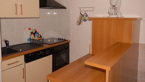 Une cuisine équipée d’une cuisinière, d’un four et d’une machine à café, le tout installé sur un plan de travail en bois.