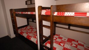 Two bunk beds with red and white bedding in a room with white walls and a dark carpet. - Comfort studio 6 ppl, terrace, pets allowed, sheets included (Gourette)