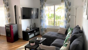 Ein Wohnzimmer mit einer Couch, einem Couchtisch, einem Fernseher und einem Heizgerät.