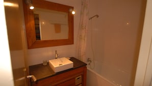 A bathroom with a wooden vanity, a white sink, a mirror, and a shower. - Comfortable studio 6 pers, slopes view, pets allowed (Gourette)