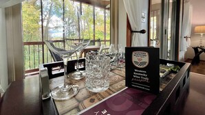 A table set with wine glasses and a sign for the Western Kentucky Wine Trail passport. - Sunfish Cove – Pet-Friendly Lakeside Retreat (Scottsville)