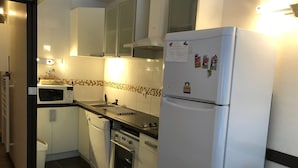 A compact kitchen with white cabinets, a microwave, a refrigerator, and a dishwasher. - Gourette Studio, 6 pax, WIFI, pets allowed (Gourette)