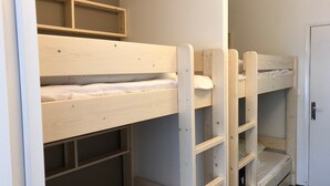 A bunk bed room with a door and a small shelf unit. - Comfortable studio, 6 pers, mountain view, pets allowed, sheets provided (Gourette)