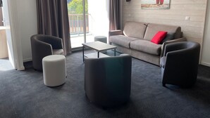 A modern living room with a sofa, two armchairs, a coffee table, and a large window with curtains. - Gourette: 66m² apt for 8, pool, pets allowed (Gourette)