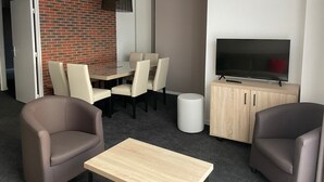 A hotel room with a dining area, a TV, and two armchairs. - Gourette: Apartment for 8, 56m², Pets Allowed (Gourette)