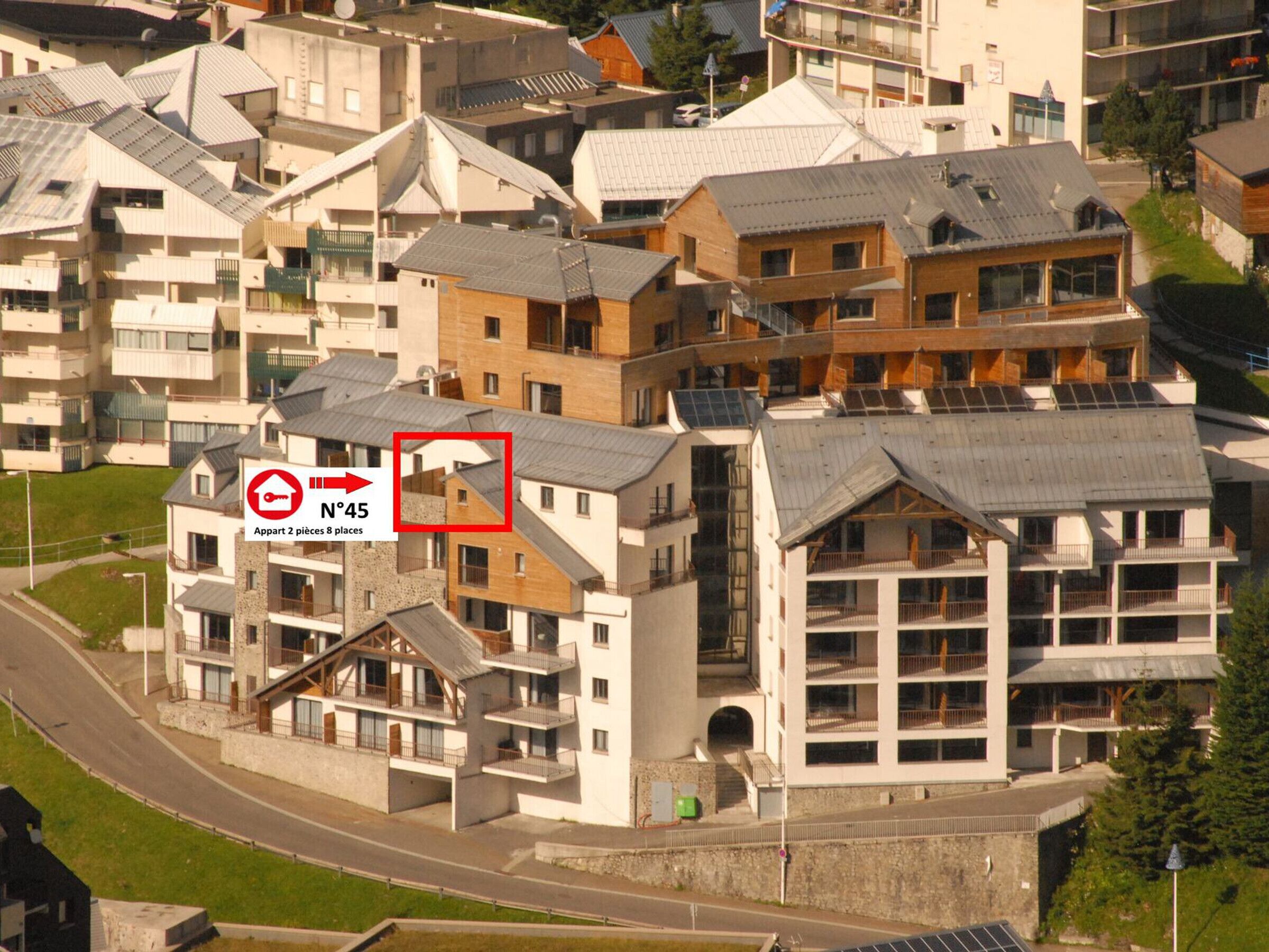 Ein mehrgeschossiges Wohngebäude mit einer Mischung aus moderner und traditioneller Architektur, mit Balkonen und Solaranlagen.