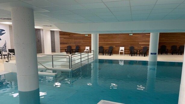 An indoor swimming pool with a wooden wall and chairs. - Gourette: Apartment for 8, 56m², Pets Allowed (Gourette)