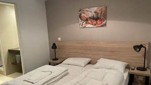 A hotel room with a large bed, two bedside tables, a headboard, and a wall-mounted artwork. - Studio cabin Gourette 6 ppl with pool and pets allowed (Gourette)