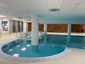 An indoor swimming pool with a central column, steps leading into the pool, and a wooden wall in the background. - Studio cabin Gourette 6 ppl with pool and pets allowed (Gourette)
