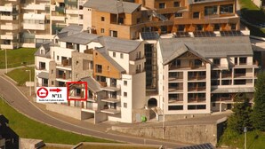 A modern residential building with multiple balconies and a mix of architectural styles. - Studio cabin Gourette 6 ppl with pool and pets allowed (Gourette)