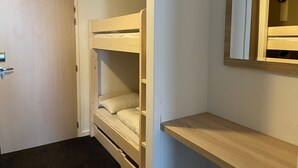 Una cama litera con estructura de madera y un pequeño estante debajo.