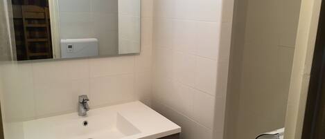 A bathroom with a white sink, a mirror, and a towel rack.