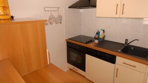 Uma cozinha compacta com lava-louças, forno e pia.