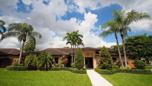 A residential house with a tiled roof, surrounded by well-maintained lawns and palm trees. - ‼️Poolside Miami Paradise w/ BBQ + Outdoor Lounge (Miami)
