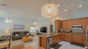 A modern kitchen with wooden cabinets, a central island, and a ceiling fan. - ‼️Poolside Miami Paradise w/ BBQ + Outdoor Lounge (Miami)