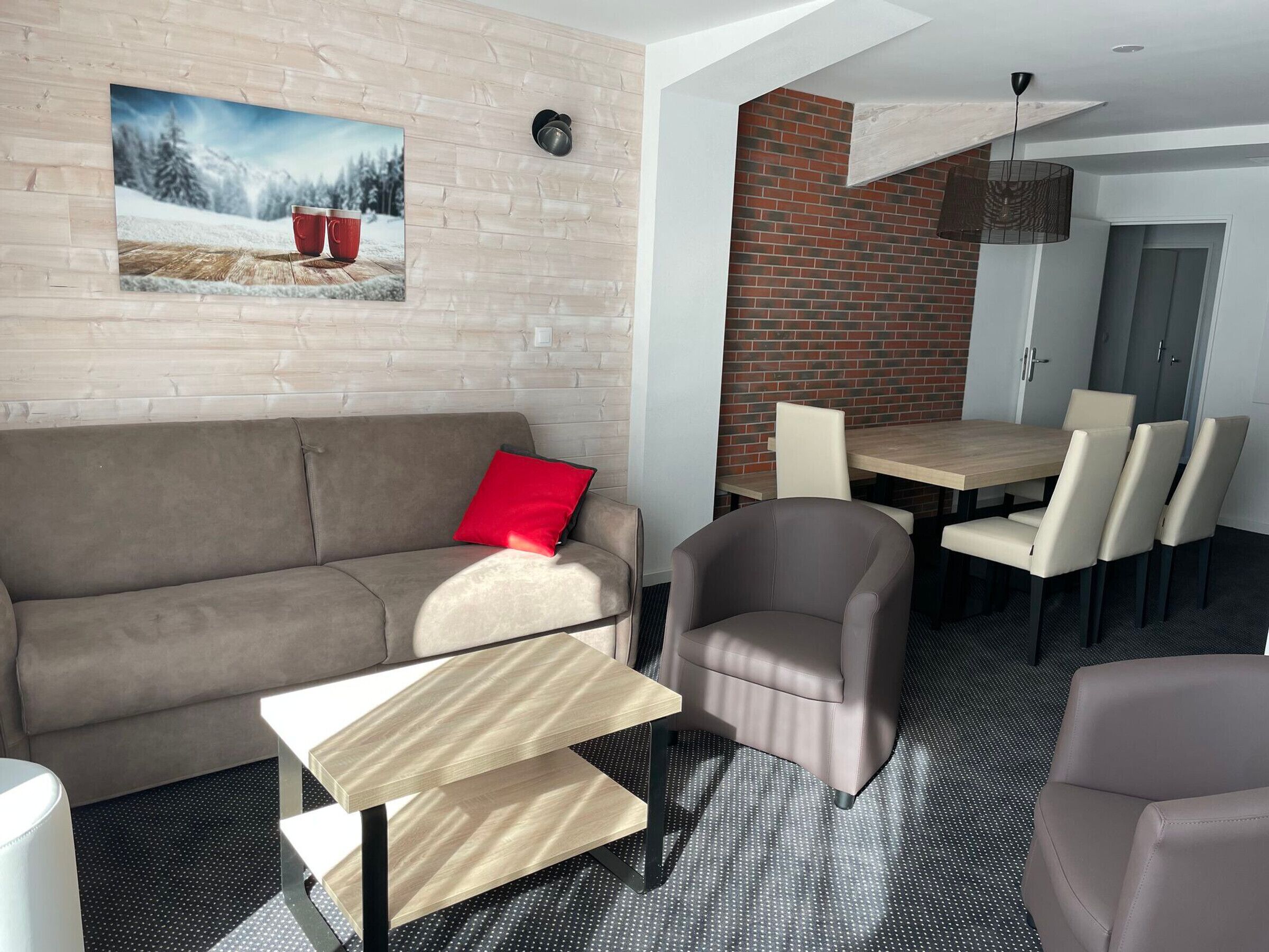 Ein modernes Wohnzimmer mit einer Couch, einem Esstisch mit Stühlen, einem Couchtisch und einem Kamin.