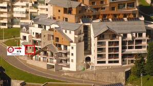 Un complejo moderno de apartamentos con varios edificios, balcones y paneles solares.
