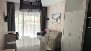 A modern room with a dining table, sofa, and a wardrobe.