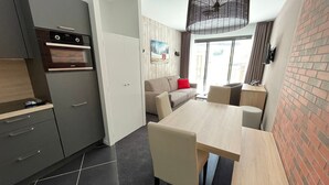 Una cocina funcional con electrodomésticos modernos, un comedor con mesa y sillas, y un amplio ventanal con vistas al exterior.