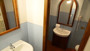 Un bagno con lavandino, specchio e water.