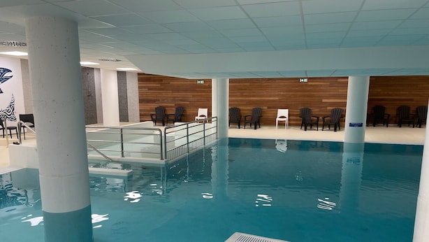 An indoor swimming pool with a wooden wall and chairs. - Gourette studio pool 4 pers., pets allowed (Gourette)