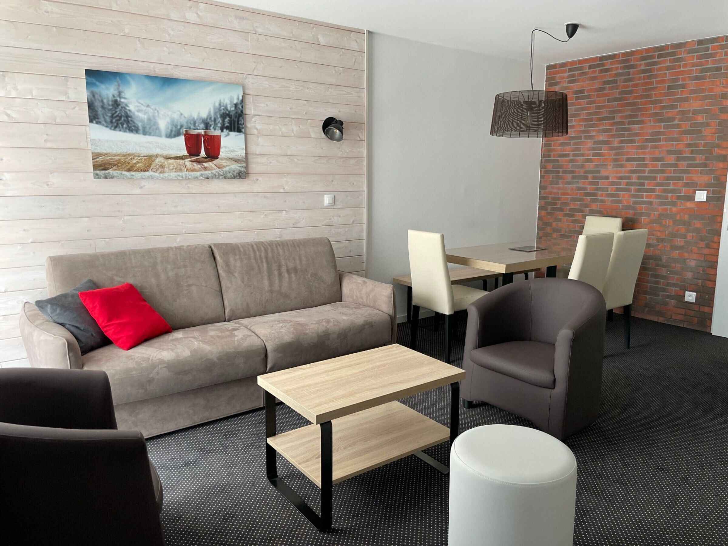 Una sala de estar moderna con sofá, mesa de centro y comedor con sillas y mesa.