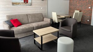 En moderne stue med sofa, sofabord og spiseområde med stole og bord.